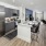 Model kitchen and living room at Prose Columbus apartments in Columbus, GA, featuring a kitchen island with counter seating.