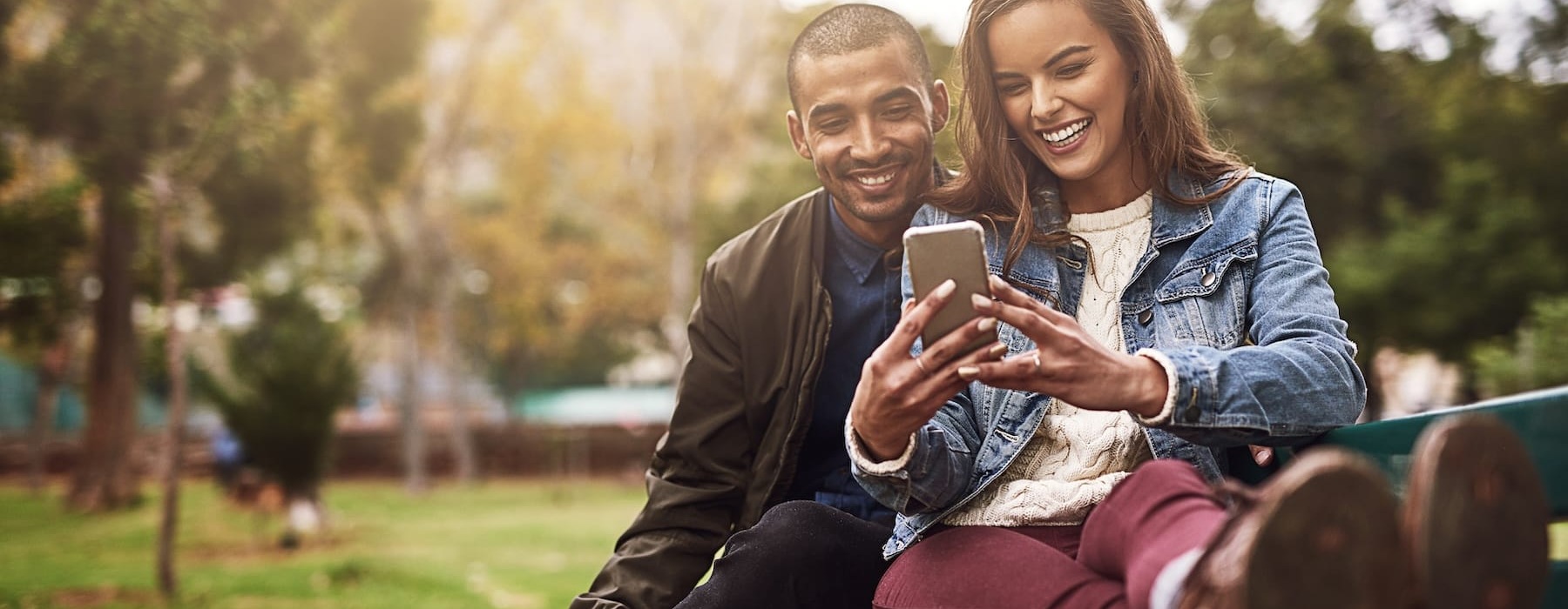 a couple looking on their phone outdoors